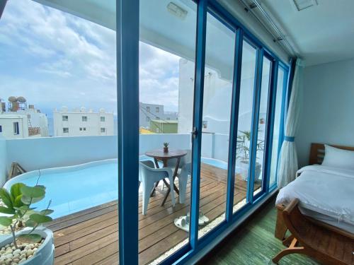 鵝鑾的住宿－墾丁藍海旅店，一间卧室设有1张床铺和1张桌子的阳台