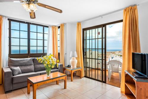 a living room filled with furniture and a tv at Club Tenerife Apartments in Los Cristianos