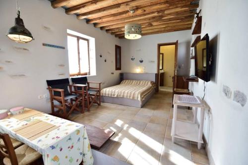 1 dormitorio con 1 cama, mesa y sillas en Poulati Guesthouse, en Artemonas