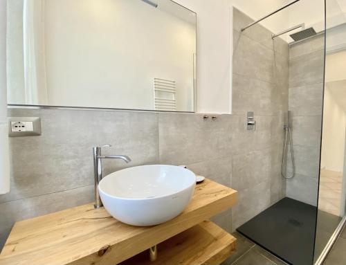 W łazience znajduje się biała umywalka i prysznic. w obiekcie Villa Verana w mieście San Vincenzo
