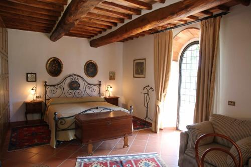 ein Schlafzimmer mit einem Bett und einem Sofa in der Unterkunft Cipressini in Castellina in Chianti