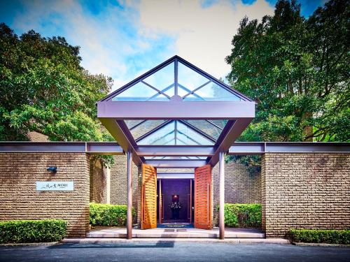 a brick building with a glass entry door at Kazenokaori Mori Premier in Ito