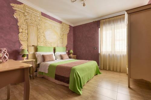 a bedroom with a large bed with a green blanket at B&B Hestasja Exclusive Rooms & Apartments in Nardò