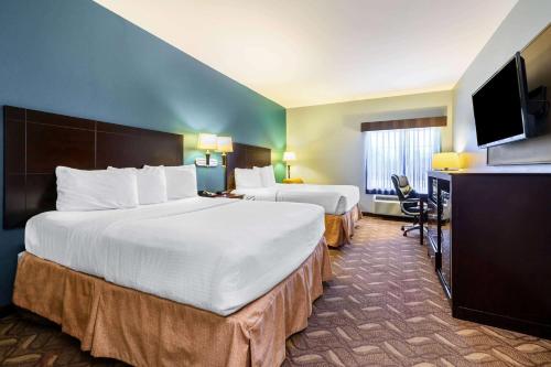 A bed or beds in a room at La Quinta by Wyndham Longview North