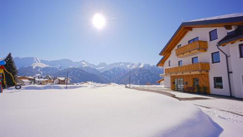 a snow covered street in front of a building at Apart-Hotel Dreisonnenhof in Fiss