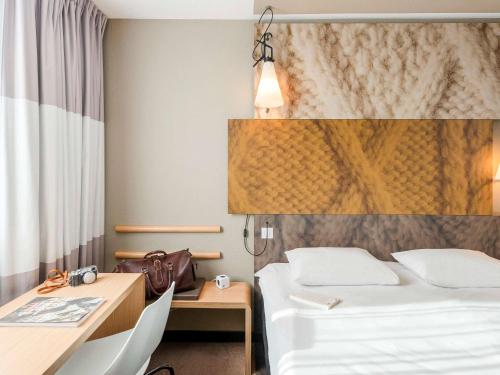une chambre d'hôtel avec deux lits et un bureau dans l'établissement ibis Lyon Caluire Cité Internationale, à Caluire-et-Cuire