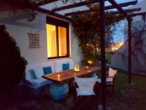 un tavolo e sedie in legno in un cortile posteriore di notte di 2 Steps from the Sea frontbeach Villa a Kalamítsi