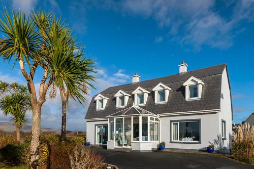 a large white house with a palm tree at Klondyke House B&B in Waterville