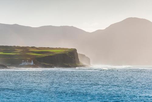 a house on a cliff next to the ocean at Klondyke House B&B in Waterville