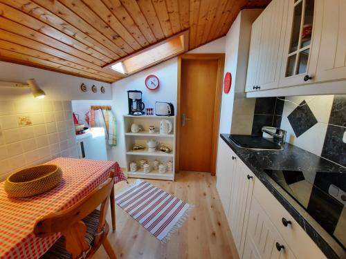 a small kitchen with a table and a refrigerator at Haus Angerbichl in Ramsau