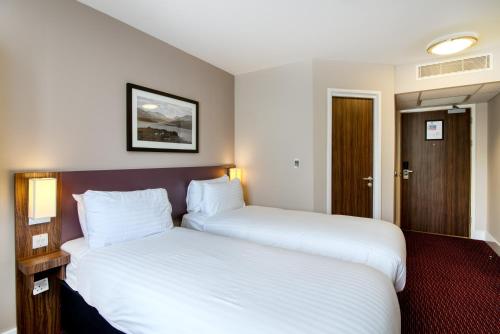 two beds in a hotel room with white sheets at Queen of the Loch, Balloch by Marston's Inns in Balloch