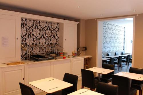 a restaurant with tables and chairs and a counter at Canalview Hotel Ter Reien in Bruges