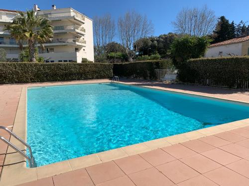 a large blue swimming pool next to a building at Studio de standing climatisé, avec piscine, proche de la mer in Fréjus