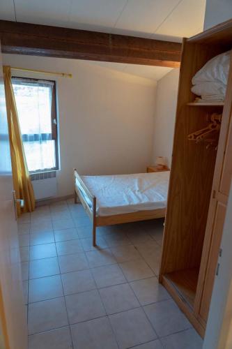 a small bedroom with a bed and a window at Gîte Mairie in Fosse