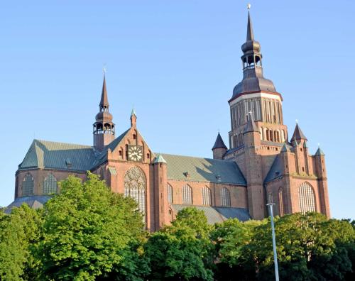 a large brick building with a clock tower on it at DEB 041 Ferienwohnung am Kurpark A in Altefähr