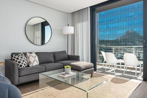 a living room with a couch and a glass table at 16 on Bree Luxury Apartments in Cape Town