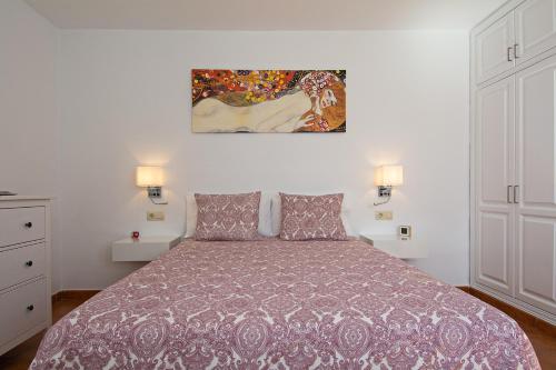 a bedroom with a bed and a painting on the wall at Apartment Fragata in Playa Honda