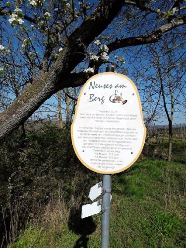 a sign sitting in the grass next to a tree at Ferienwohnung - Zimmervermietung Ringelmann in Dettelbach