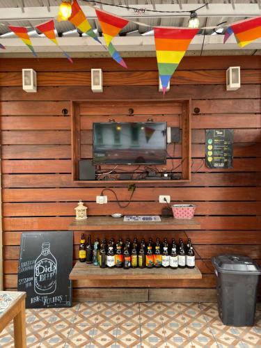 a room with a television and a shelf of beer bottles at Did's Hostel São Paulo in Sao Paulo