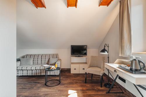 a living room with a couch and a table at Hotel Batory in Szczawnica