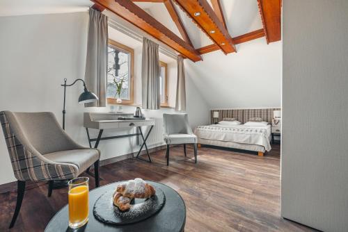a living room with a table and a bedroom at Hotel Batory in Szczawnica