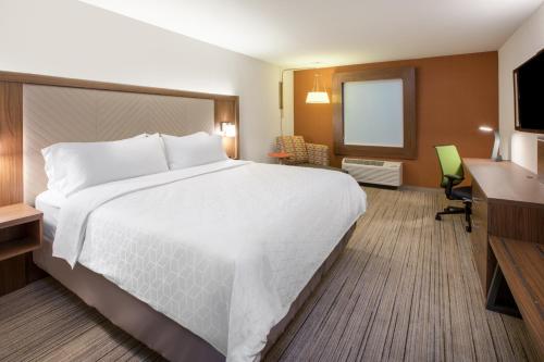 Habitación de hotel con cama grande y escritorio. en Holiday Inn Express & Suites Dayton East - Beavercreek en Beavercreek