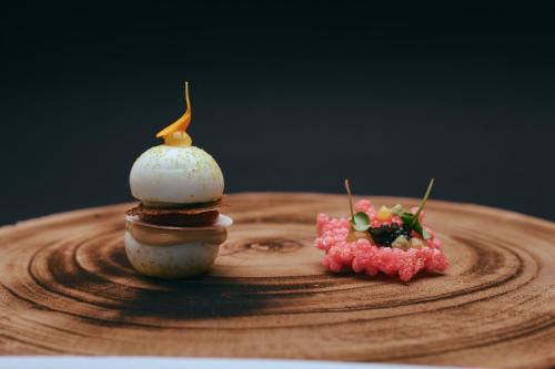two desserts sitting on top of a wooden plate at Hotel Roter Hahn in Regensburg