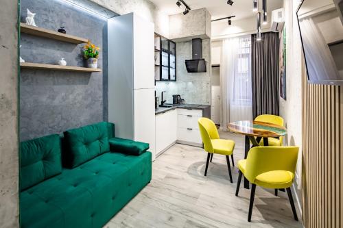 a living room with a green couch and yellow chairs at Alfa Apartments Kulisha 12 in Lviv