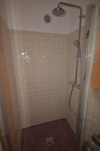 La salle de bains est pourvue d'une douche et d'un mur carrelé. dans l'établissement LE DIX Duplex historical center balcony with view and air conditioning, à Aix-en-Provence