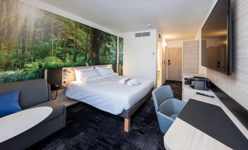 a bedroom with a bed and a large painting on the wall at Novotel Rennes Alma in Rennes