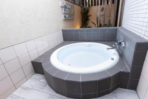 a bathroom with a bath tub with a sink at ホテル ロコガーデン 三重菰野 in Komono