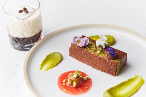 a plate of food with a piece of cake and a pickle at Riva Boutique Hotel in Helensburgh
