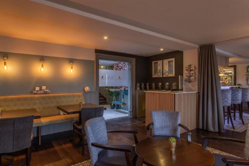 a restaurant with tables and chairs and a bar at Riva Boutique Hotel in Helensburgh