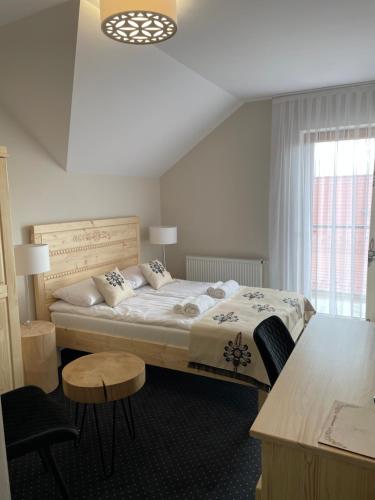 a bedroom with a bed and a table and a window at Pienińska Ostoja in Czorsztyn