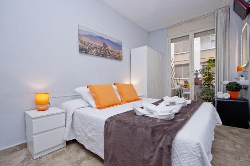 Un dormitorio con una cama y una mesa con toallas. en Barcelona City Seven, en Barcelona