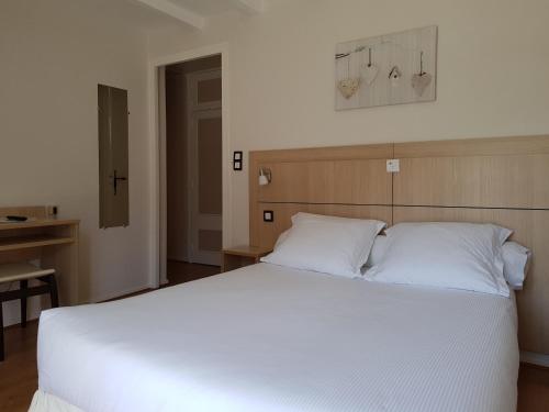 a bedroom with a large white bed with white pillows at Le Chabi in La Chapelle-dʼAbondance