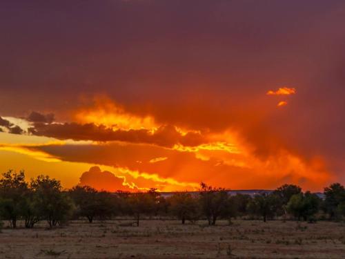 a sunset in the desert with orange clouds at The Ancient Copper Shed in Potchefstroom