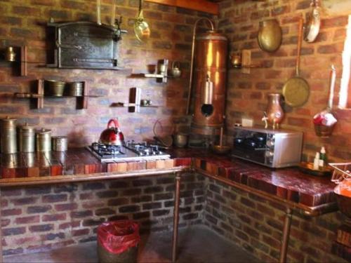 a kitchen with a brick wall and a stove at The Ancient Copper Shed in Potchefstroom