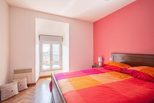 een slaapkamer met een kleurrijk bed en een raam bij Gîte de la Forge in Millières