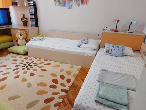 a small room with two beds and a rug at Sweet Home in Burgas City