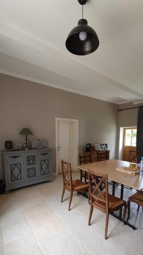 une salle à manger avec une table et des chaises en bois dans l'établissement Les chambres du Foulot, à Beaune