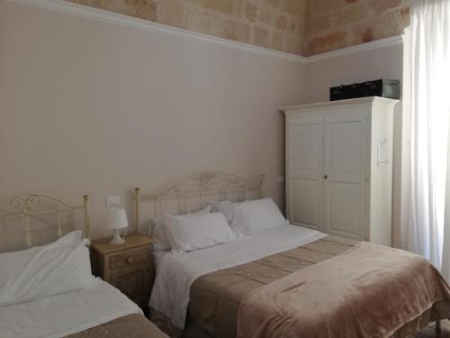 a bedroom with two beds and a window at Al Rosa Antico in Monopoli