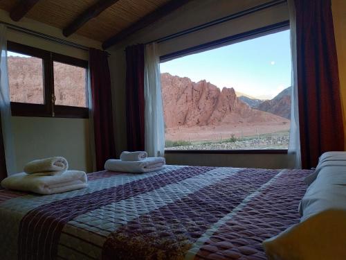 a bedroom with a bed with a view of the desert at Pirca del Abuelo II in Purmamarca