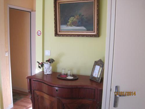 a room with a wooden cabinet and a picture on the wall at Hotel Le Commerce in Neuville