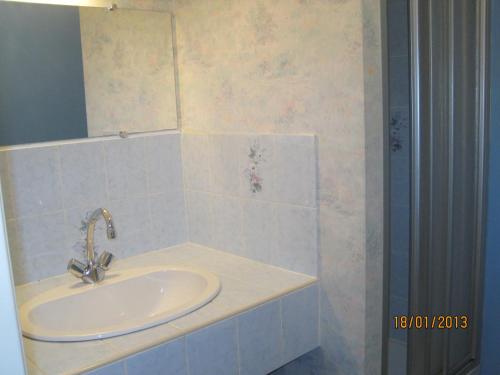 a bathroom with a sink and a mirror at Hotel Le Commerce in Neuville