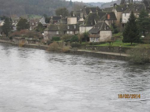 a town next to a river with houses at Hotel Le Commerce in Neuville