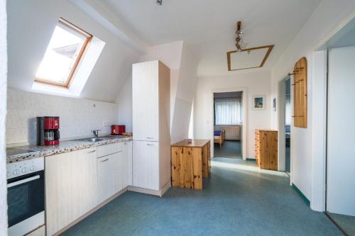 a kitchen with white cabinets and a skylight at Ferienwohnung 3, Waldesruh Dierhagen in Dierhagen