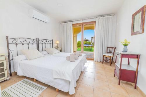 a bedroom with a large white bed and a table at E227 Sa Pedrera by Mallorca Villa Selection in Caʼs Concos