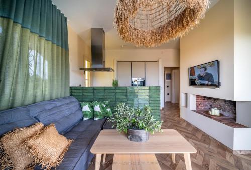 a living room with a blue couch and a table at My Cool House in Porto Heli