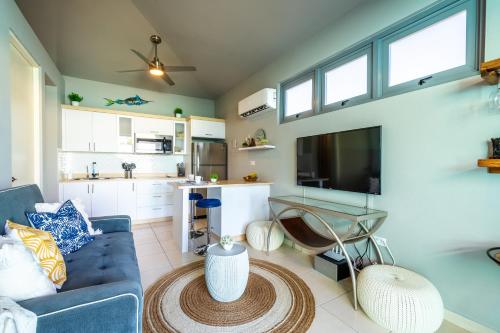 a living room with a blue couch and a kitchen at Villas at Aguada Sea Beach in Aguada